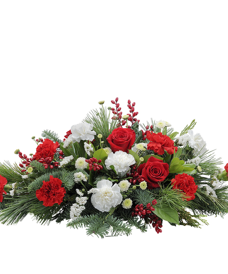 Christmas centerpiece of red and white flowers accented with winter greenery and red berries
