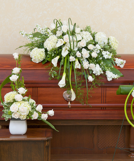 Trio of funeral arrangements: One casket spray, cross and tribute of white flowers.