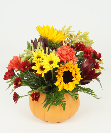 fall-toned floral arrangement in pumpkin vase
