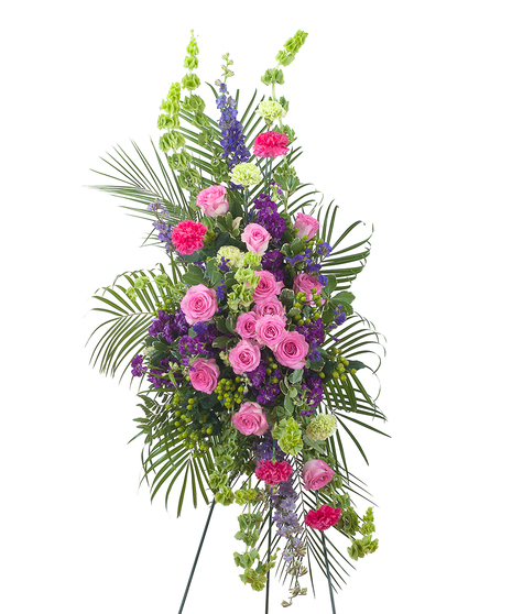 Easel spray of bright pink and purple flowers with greenery. 