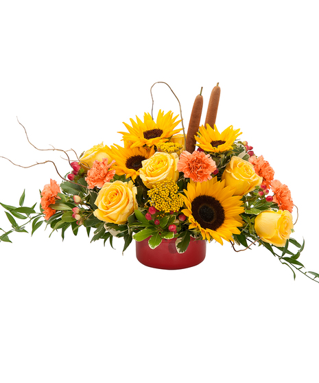 Fall centerpiece of autumn flowers including roses and sunflowers.