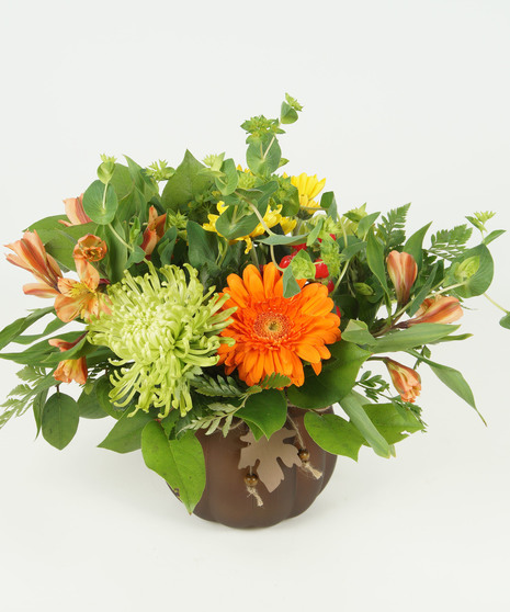 fall toned floral arrangement in pumpkin vase