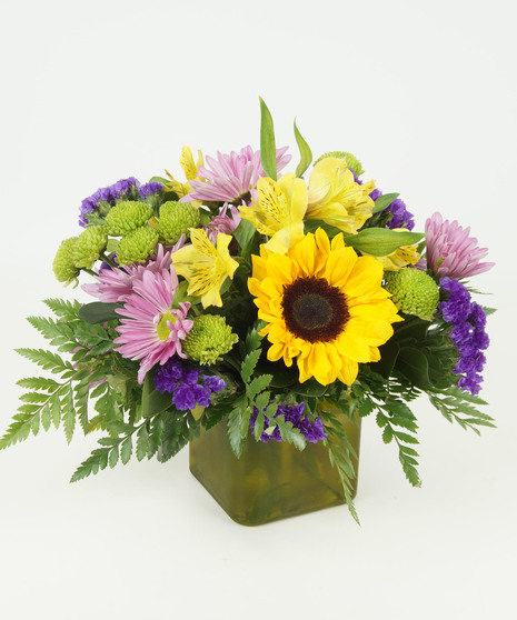 yellow and purple floral arrangement in green square vase