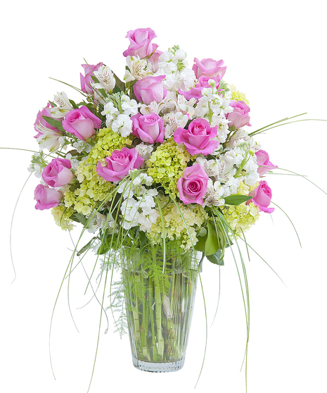 Pink roses, white alstroemeria, green hydrangea and premium foliage in a clear glass vase. 