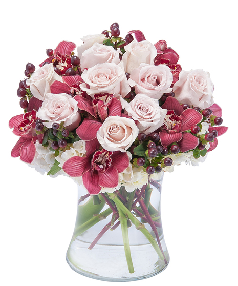 Hydrange and orchids with berries in a clear vase. 