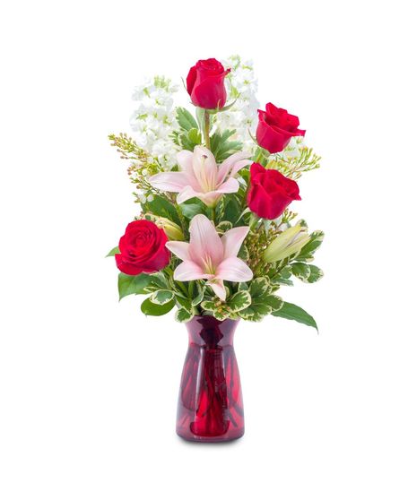Lilies and roses in a red glass vase. 