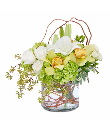 Lilies, roses, orchids and hydrangea in a clear vase accented with curly willow