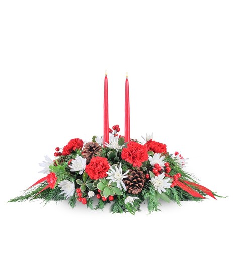 Christmas centerpiece of evergreens, red carnations, white chrysanthemums and a taper candle.