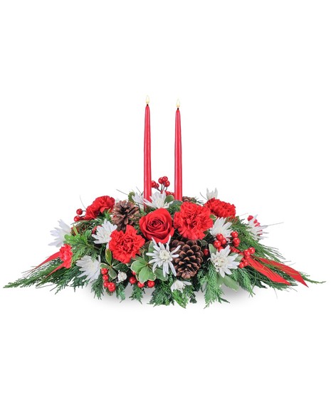 Christmas centerpiece with red and white flowers, evergreens and a red taper candle