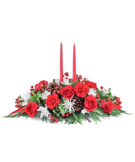 Christmas centerpiece with red and white flowers, evergreens and a red taper candle