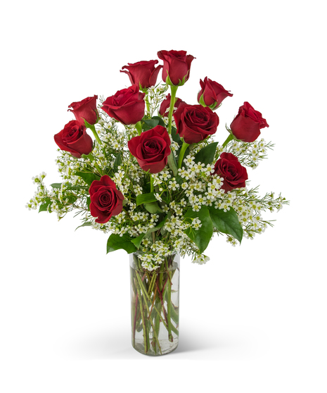 One dozen red roses and greenery in a clear vase