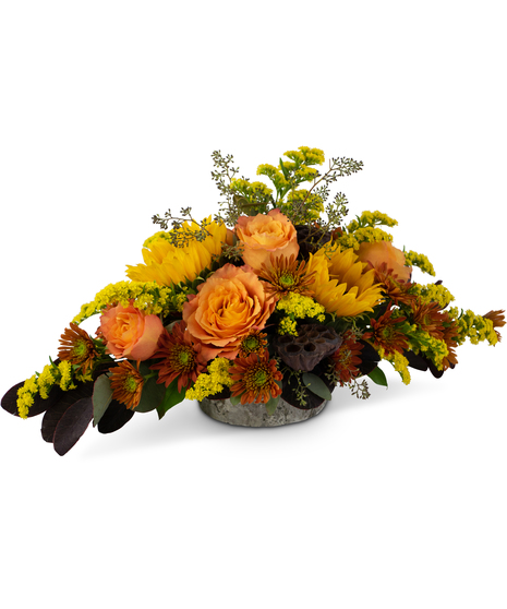 Autumn centerpiece with roses, sunflowers, solidago, mums and lotus pods in a weathered oak vase.