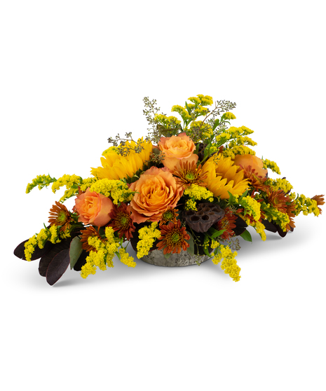 Autumn centerpiece with roses, sunflowers, solidago, mums and lotus pods in a weathered oak vase.