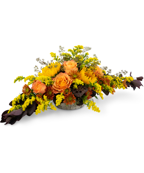 Autumn centerpiece with roses, sunflowers, solidago, mums and lotus pods in a weathered oak vase.