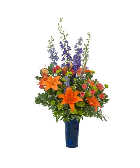Lilies, roses, mums and larkspur in a cobalt blue bud vase.