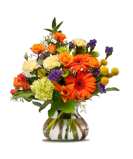 Bright fall flowers arranged in a clear vase.