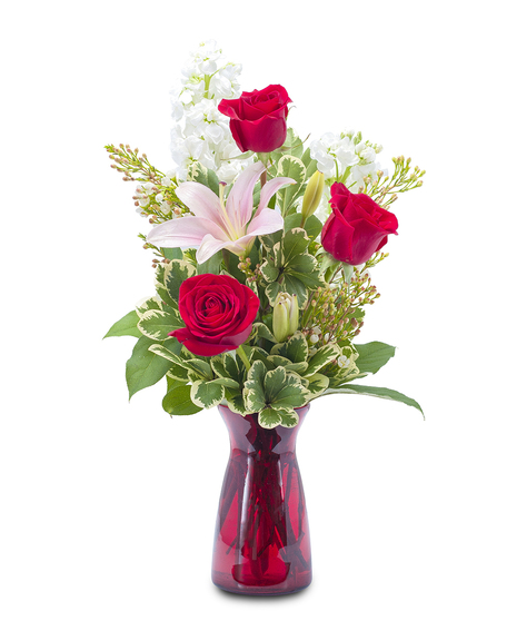 Lilies and roses in a red glass vase. 